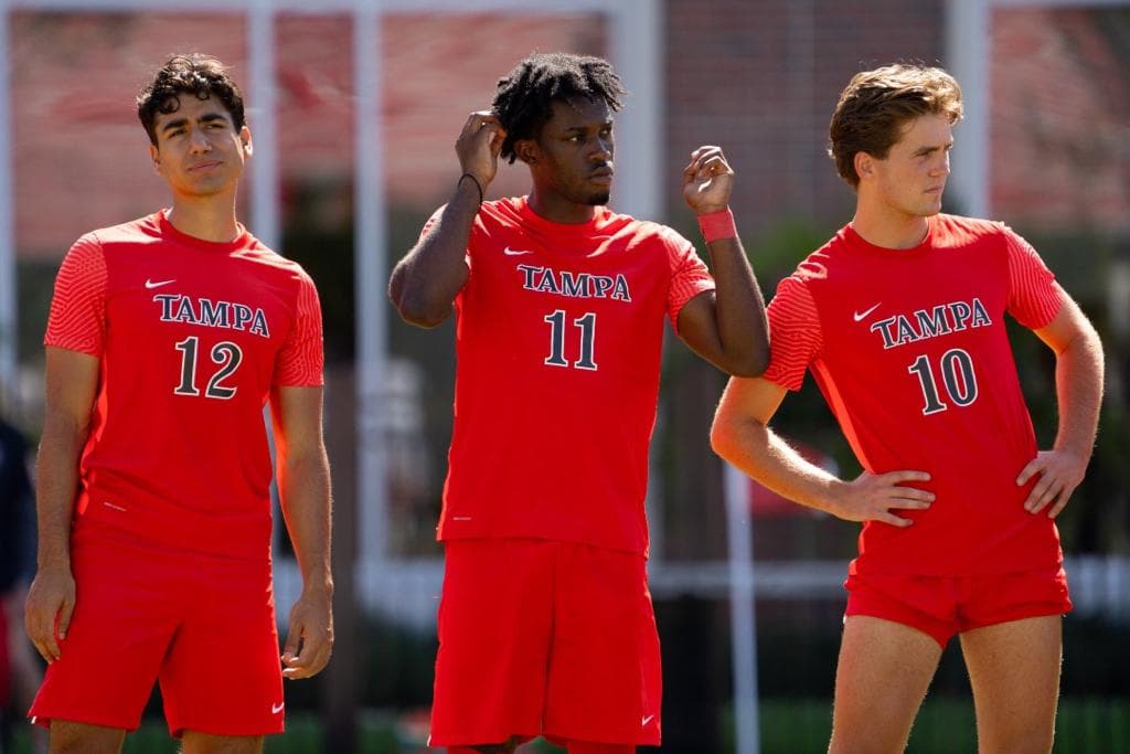 Three Tampa student-athletes standing together on the pitch
