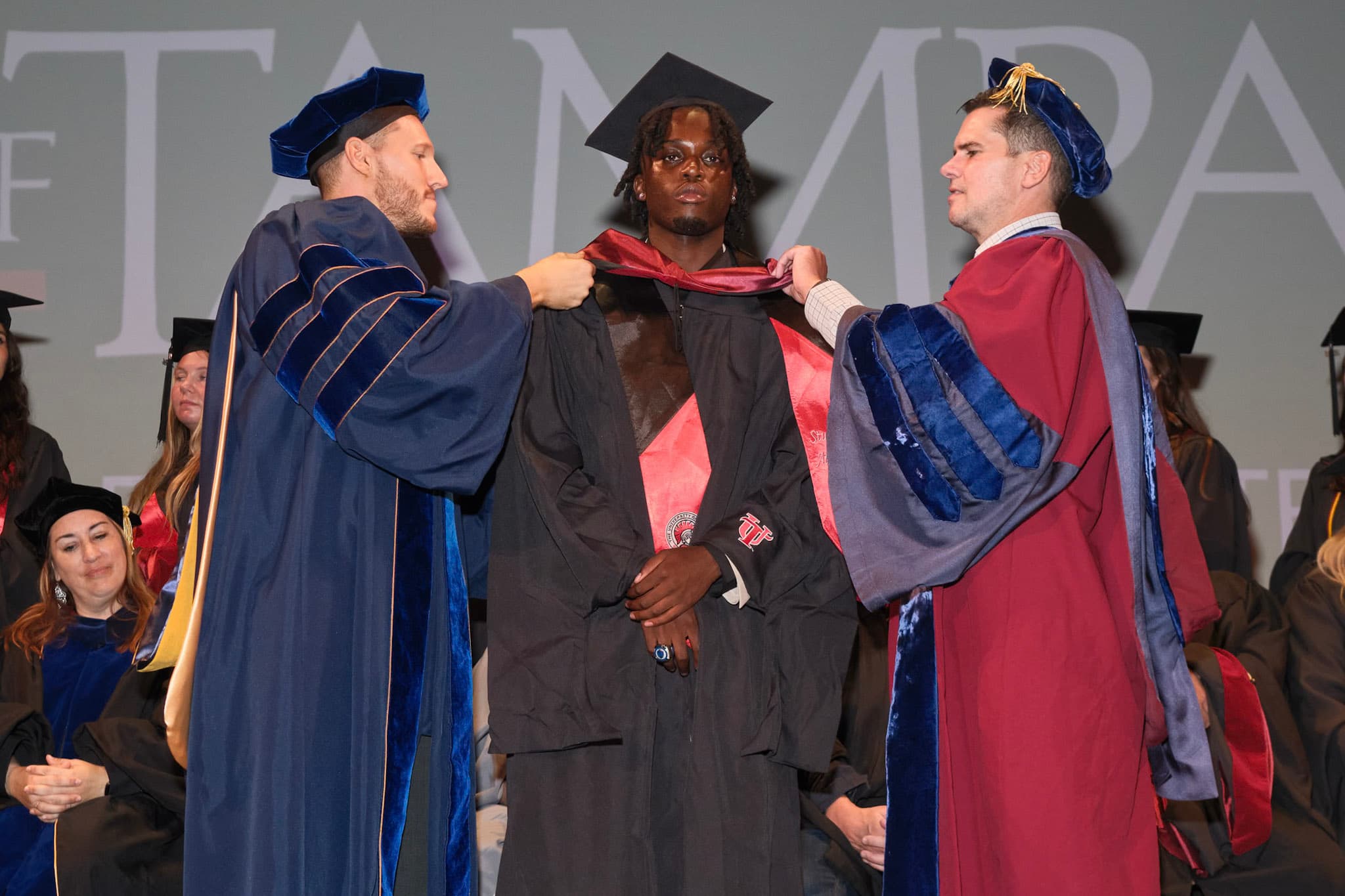 A graduate receiving his academic hood during a university ceremony