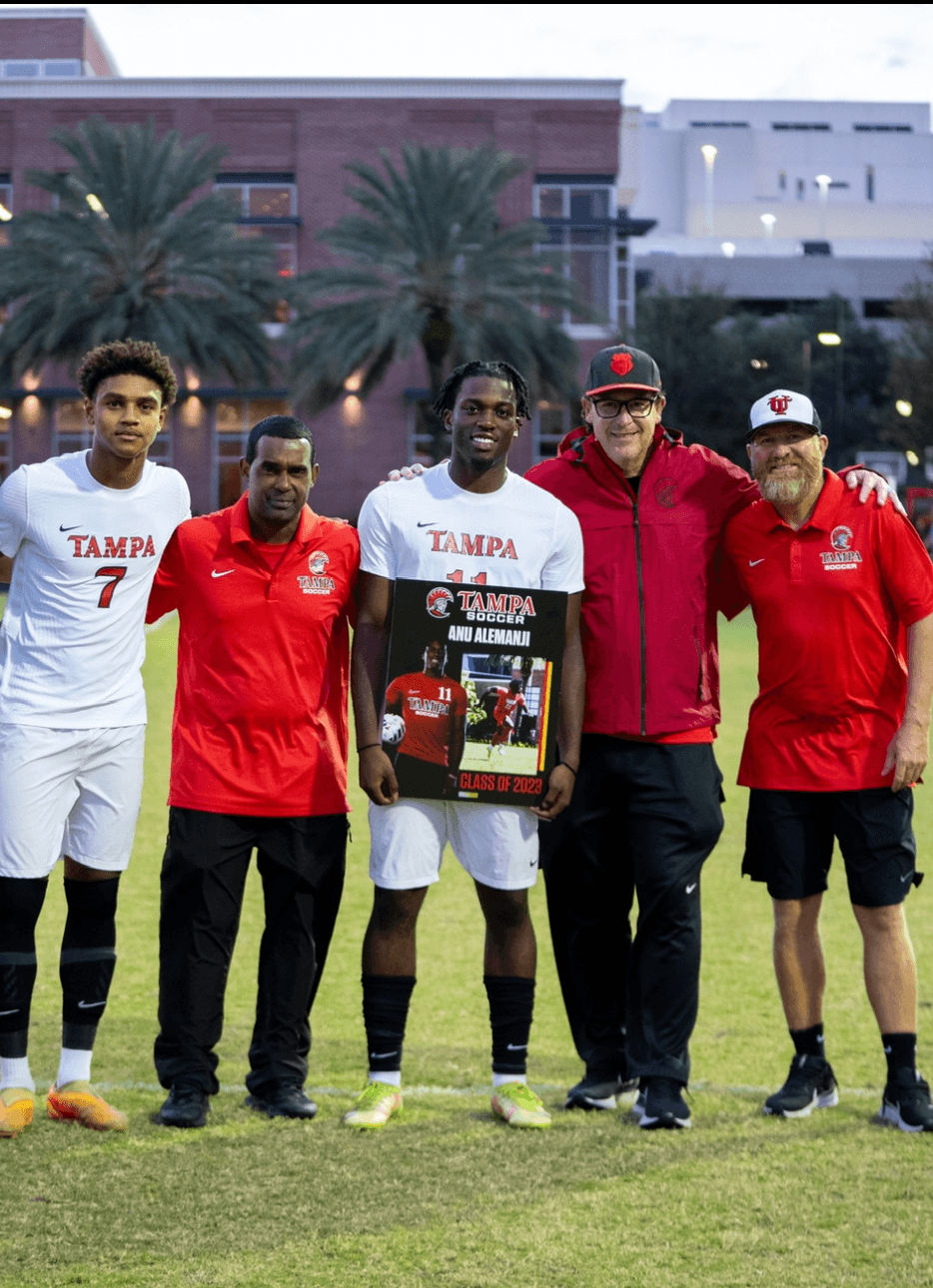 Tampa football players and coaches celebrating a graduating player